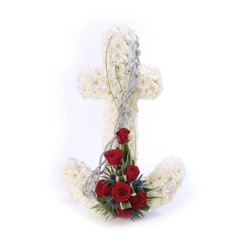 An anchor shaped design using a mass of white double spray chrysanthemums with a feature spray of red short stemmed roses and a contrasting blue eryngium. The tribute is finished with green foliage and a silver cord.
