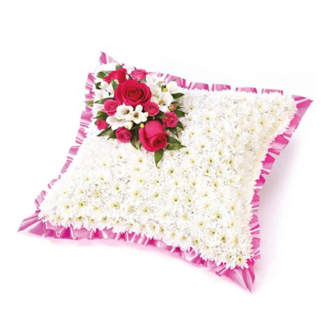A classic cushion-shaped design created using a mass of white double spray chrysanthemums and finished with a spray of cerise roses and white freesias and a pink ribbon trim.